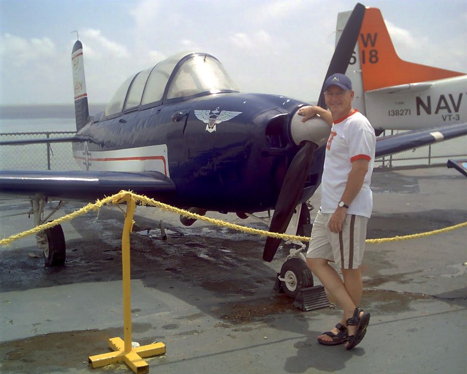 Texan Mike Kimbro in front of a Navy training aircraft on the flight deck of the USS Lexington in Corpus Christi Bay in August 2007.