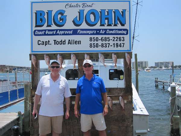 Gary Maxwell and Lee Skaalrud standing in front of the Big John charter boat of Capt Todd Allen which sails out of Destin Harbor near the Emerald Grande at Harborwalk Village.