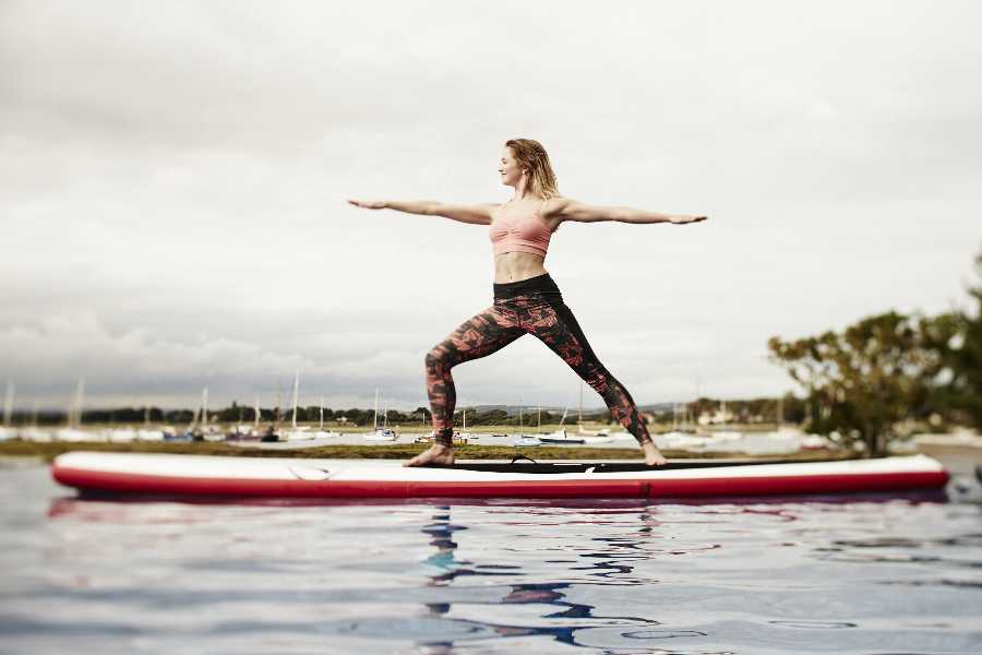 Photo of young lady practicing yoga on a windsurfer like paddle board, while wearing camo yoga pants by the English fitness fashion house Sweaty Betty, home of the finest in active couture.  I do not have ownersip of this photograph.