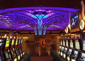 Pic of a couple rows of slot machines at a casino somewhere in America.