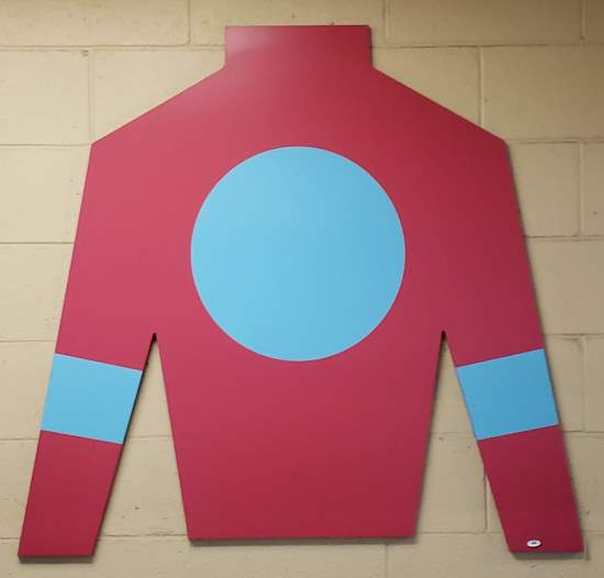 Photo taken at Churchill Downs, of an image of silks worn by a jockey in the colors claret and blue.