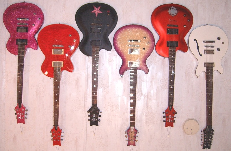 My Daisy Rock Electric Guitar Collection, including (from L to R) the Rock Candy in Atomic Pink, the Rock Candy Special, the Dark Star model of the Rock Candy Custom, the Stardust Elite, the Aztec Goddess model of the Rock Candy Custom, and the Retro-H 12-String guitar.