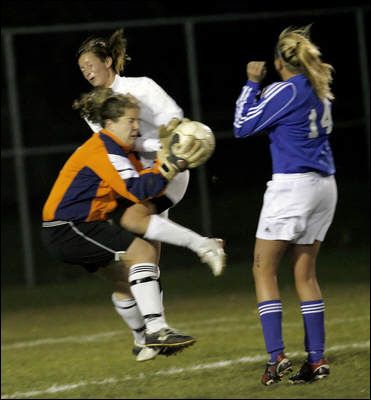 Photo Credit:  by Photographer Joe Vitti of The Indianapolis Star, Noblesville's Allie Vandewater (in white) collides with Carmel High School goalkeeper Emma Gormley. Carmel's Jessica Rix is at right.  Yes indeed, this is Indiana girl's high school action.