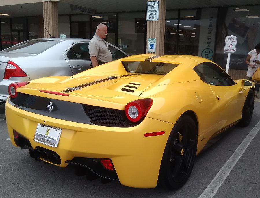Deputy Sheriff Pat Jones inspects vehicles at the office of the Jefferson County Clerk in the East End of Louisville, Kentucky, this one bought from Ferrari of Beverly Hills in California.