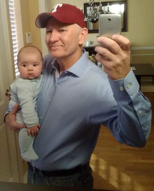 Selfie Time!  In this photo Chrome Dome Mike holds his grandchild Luke Neilon, in a photo taken in a mirror.