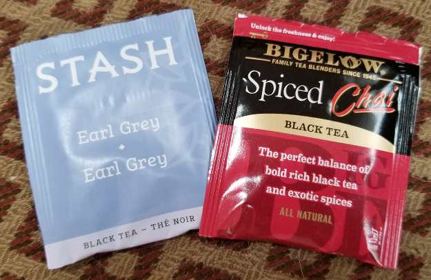 A pic of 2 tea bags, on the left is Earl Grey by Stash Teas, on the right is Spiced Chai by Bigelow Family Tea Blenders, both made with black tea.