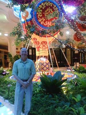 Poet Chrome Dome Mike in front of the fake rose covered hot air balloon in the artium of the Wynn Las Vegas Resort.  Photo taken by Ms Fernanda Persson.