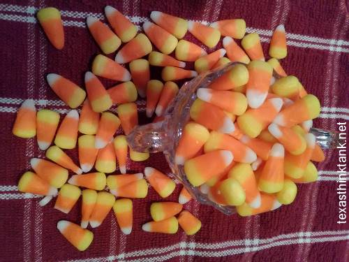 A pic of delicious candy corn in a crystal bowl on a red and white dish towel.