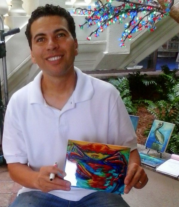 Marine life artist Kelly Pierre of the True Colors Studio signing a work of paint on ceramic tile at the Emerald Bay at Harborwalk Village in Destin, FL, which became a wedding gift for Mr. and Mrs. Ed Johnson of Dallas, Texas.