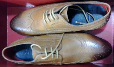 In taupe or tan, wingtip oxford brogue men's shoes with heavy burnishing, found at Sax Fifth Avenue - Off 5th Avenue in the outlet mall at Grapevine, Texas, USA.