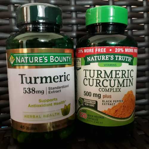 A photo of two bottles of the supplements Tumeric and Curcumin, one with black pepper extract, by the drug companies Nature's Bounty and Nature's Truth.